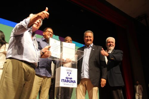 Prefeito Augusto Castro ao lado de autoridades, mostra a Ordem de Licitação do Mais Água III.